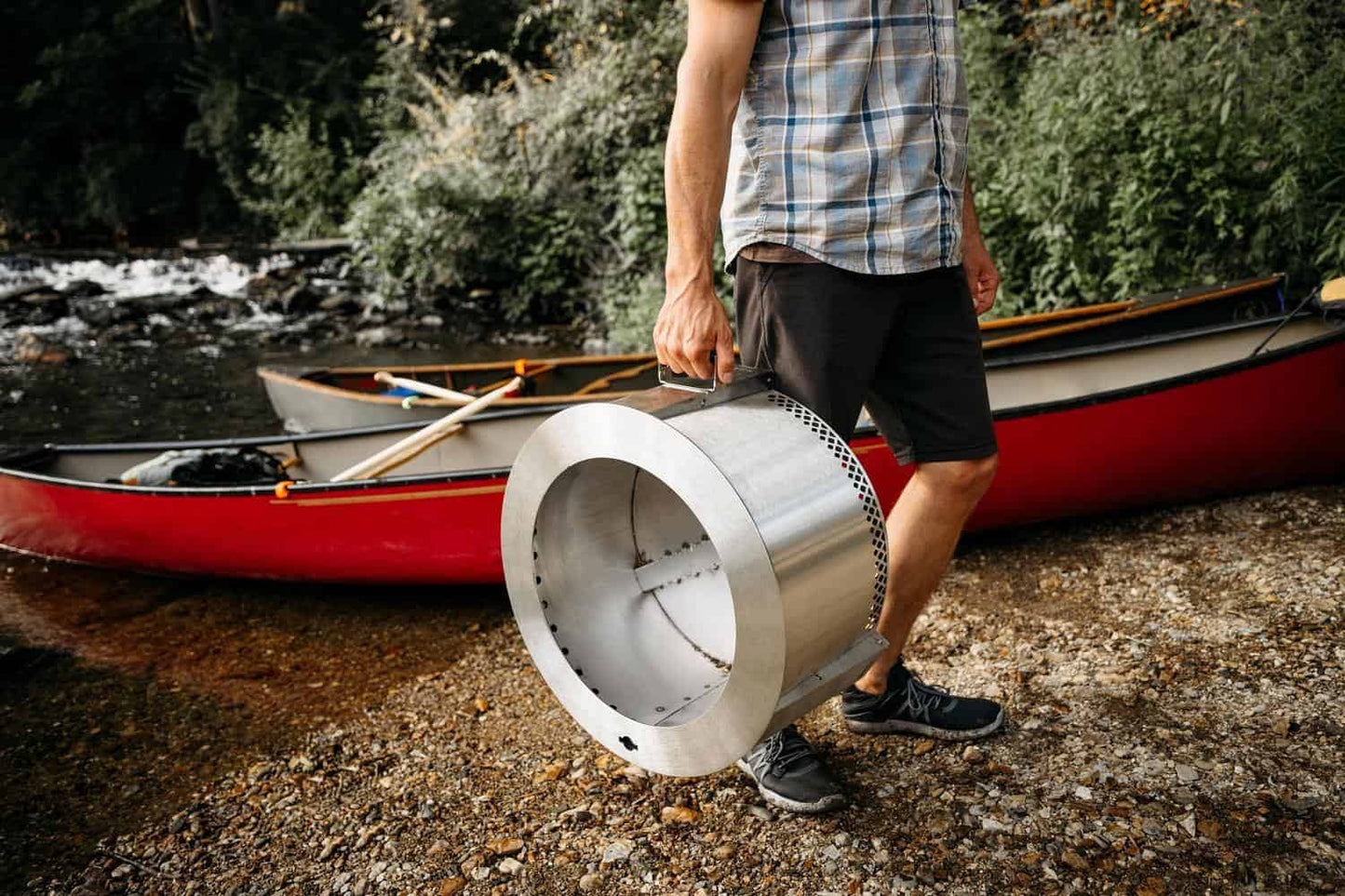 An image of a man carrying the Y Series Firepit